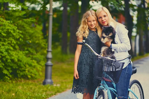 Матір з донькою тримати собаку шпіц — стокове фото
