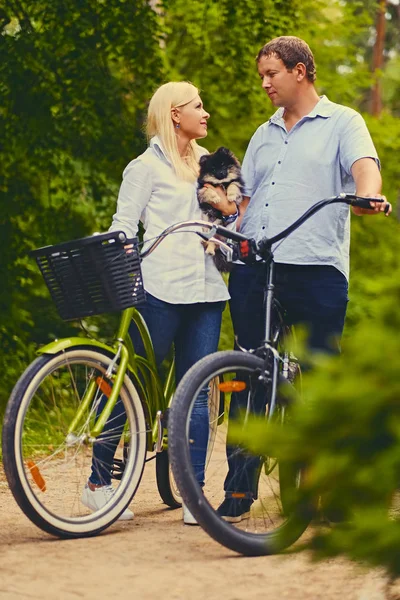 金发碧眼的女及一名男子骑着自行车 — 图库照片