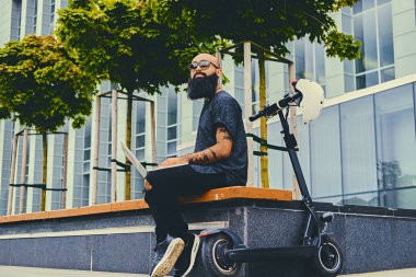 Sakallı erkek bir dizüstü bilgisayar kullanarak