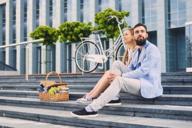 Bir çift bir adım piknik sepeti ile oturur.