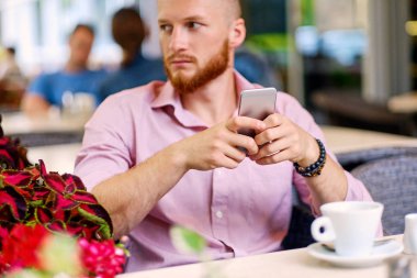 Bir smartphone kullanarak rahat Kızıl saçlı erkek