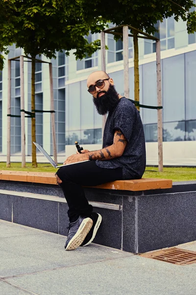 Shaved head man using a laptop