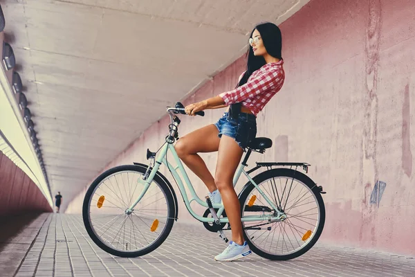 Девушка в джинсовых шортах на велосипеде — стоковое фото