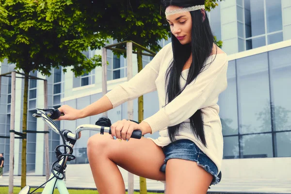 Morena feminina em uma bicicleta — Fotografia de Stock