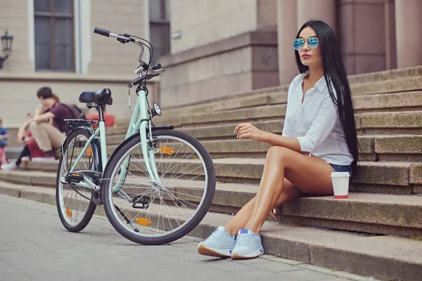 Mujer con bicicleta de la ciudad en el fondo . — Foto de Stock