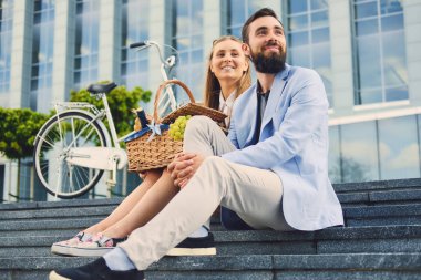 Bir çift bir adım piknik sepeti ile oturur.