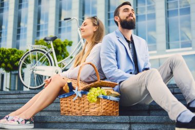 Bir çift bir adım piknik sepeti ile oturur.