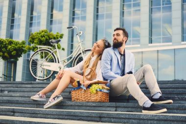 Bir çift bir adım piknik sepeti ile oturur.