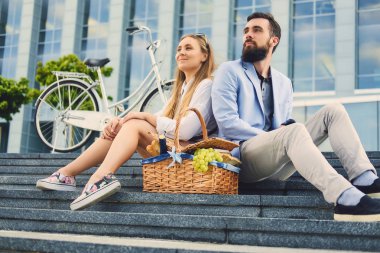 Bir çift bir adım piknik sepeti ile oturur.