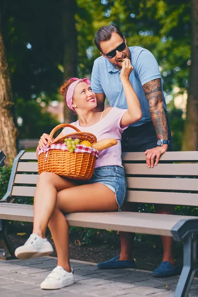 Férfi és a vörös hajú nő birtoklás egy piknik — Stock Fotó