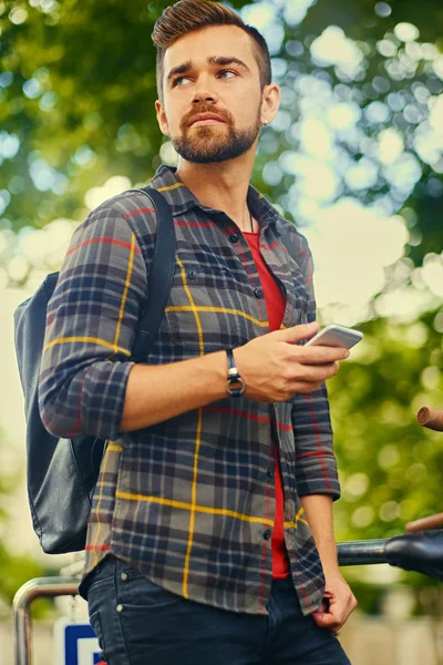 Man talks by a smart phone in a park — Stock Photo, Image