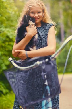 Sarışın kız bir Spitz köpek tutar