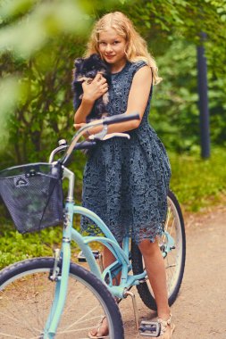 Sarışın kız bir Spitz köpek tutar