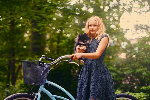 Blond dziewczyna trzyma psa Spitz — Zdjęcie stockowe