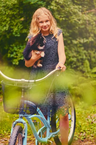 Sarışın kız bir Spitz köpek tutar