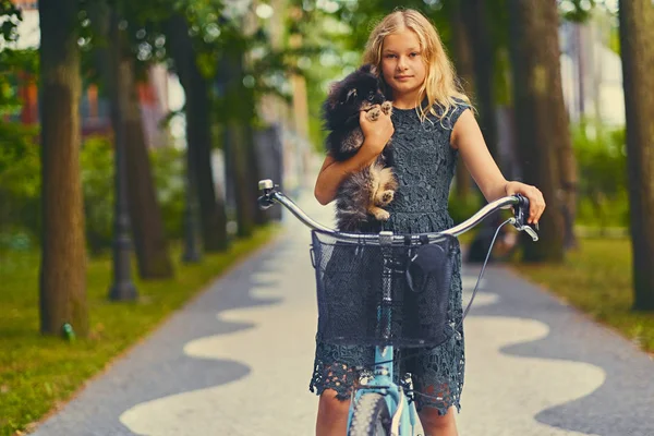 Sarışın kız bir Spitz köpek tutar