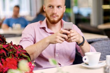 Bir smartphone kullanarak rahat Kızıl saçlı erkek 