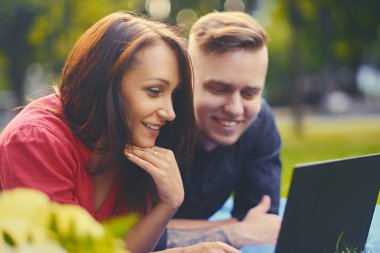 Pikniğe bir dizüstü bilgisayar kullanarak çekici çift