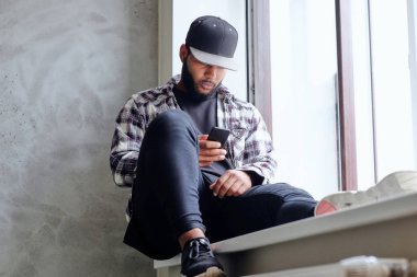 Siyah erkek pencere oturur 