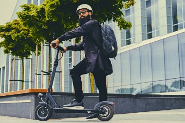 Elektrikli scooter üzerinde poz adam.
