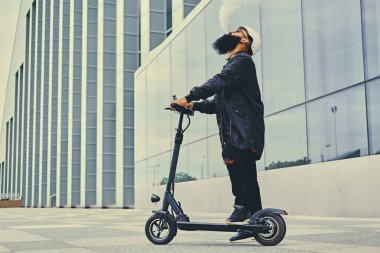 erkek vaping ve tarafından elektrikli scooter sürme