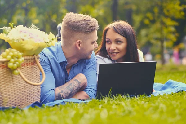 Paar mit Laptop auf dem Rasen — Stockfoto