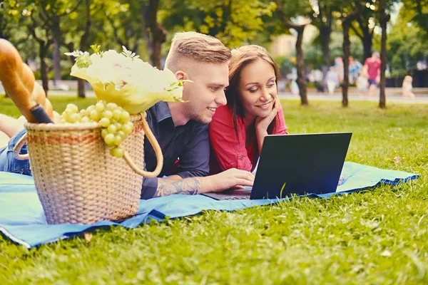 Couple sur une pelouse en utilisant un ordinateur portable — Photo