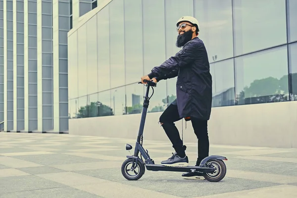 Elektrikli scooter üzerinde poz adam.