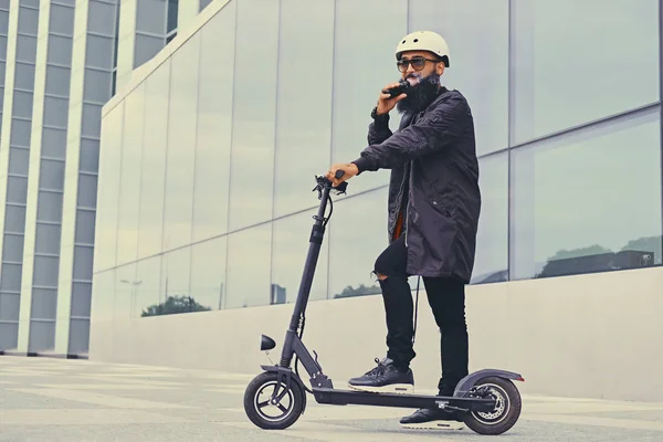 Vapeo masculino y montar en scooter eléctrico —  Fotos de Stock