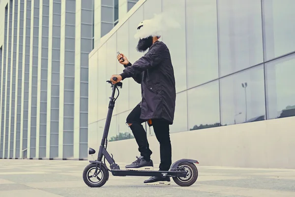 Mannelijke vaping en paardrijden door elektrische scooter — Stockfoto