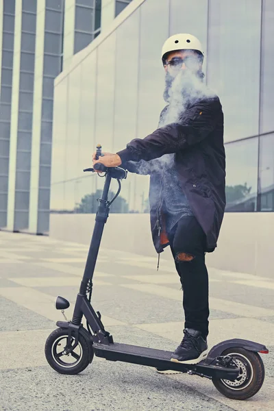 Mannelijke vaping en paardrijden door elektrische scooter — Stockfoto