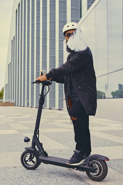 Mannelijke vaping en paardrijden door elektrische scooter — Stockfoto