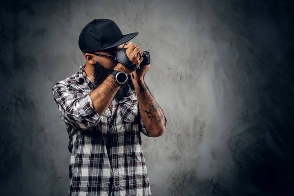 Barbudo hipster sostiene cámara — Foto de Stock