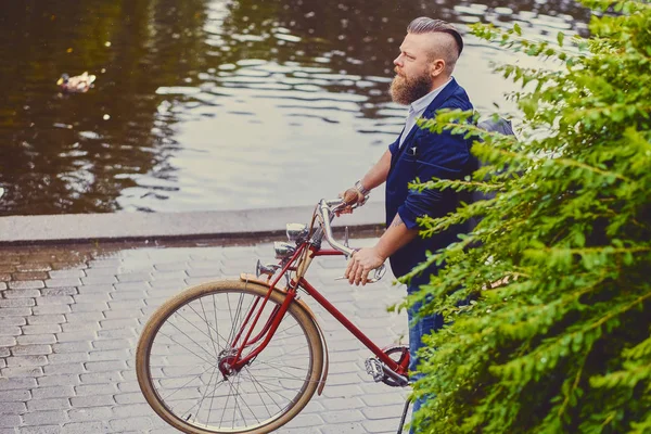 Человек с ретро-велосипедом в парке — стоковое фото
