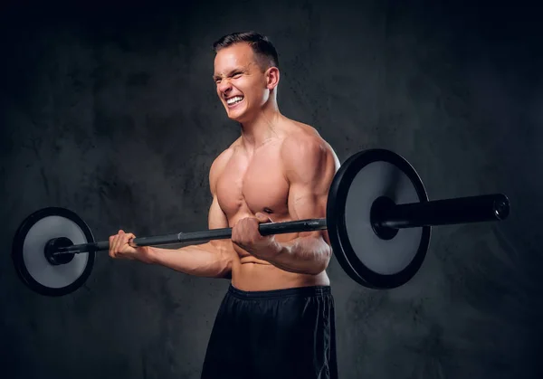 Muscular macho sostiene la barra — Foto de Stock