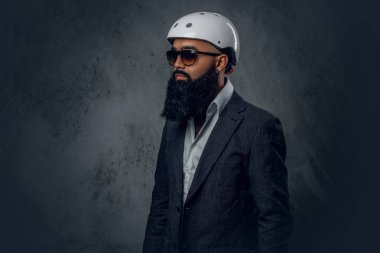 Sakallı erkek bir gri takım elbise giymiş.