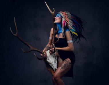 Hintli erkek bir boynuz kafatası tutar.