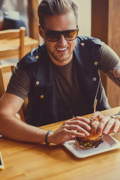 Hipster äta en vegan hamburgare — Stockfoto