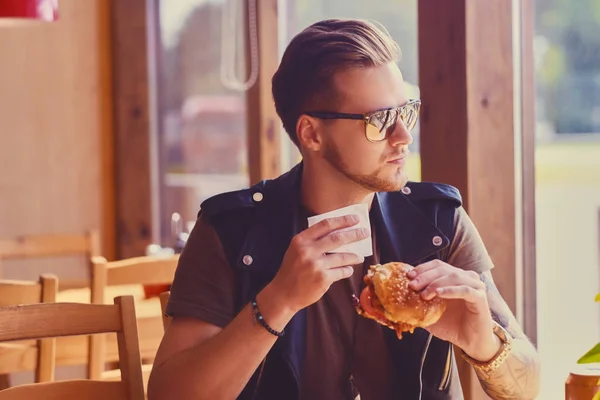 Hipster eating a vegan burger