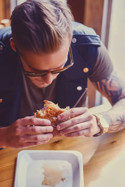 Hipster äta en vegan hamburgare — Stockfoto