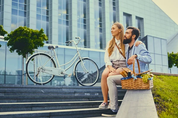 Een paar zit op een stap met picknickmand. — Stockfoto