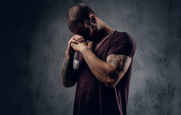 Grave maschio tatuato che prega — Foto Stock