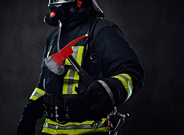Πυροσβέστης σε μια ενιαία κατέχει ένα κόκκινο τσεκούρι. — Φωτογραφία Αρχείου