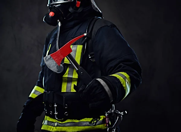 Bombeiro de uniforme segura um machado vermelho . — Fotografia de Stock