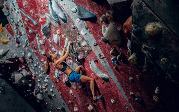 Scalatrice professionista su una parete boulder . — Foto Stock