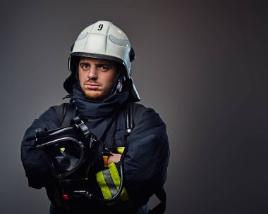 İtfaiyeci üniforması ve güvenlik kask içinde.