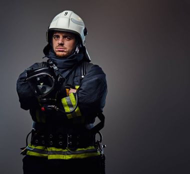 İtfaiyeci üniforması ve güvenlik kask içinde.