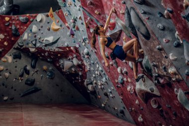 Profesyonel kadın dağcı bouldering duvara.