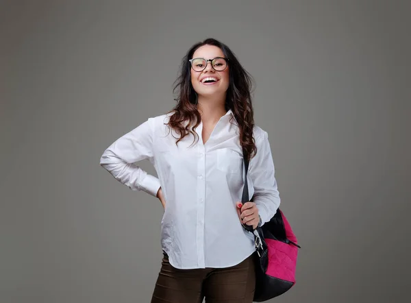 Brunette meisje met een zak roze reiziger. — Stockfoto