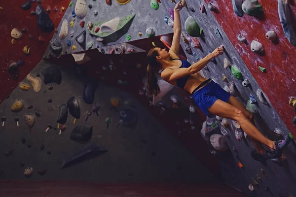 Vrouwelijke klimmer. Extreme indoor klimmen. — Stockfoto
